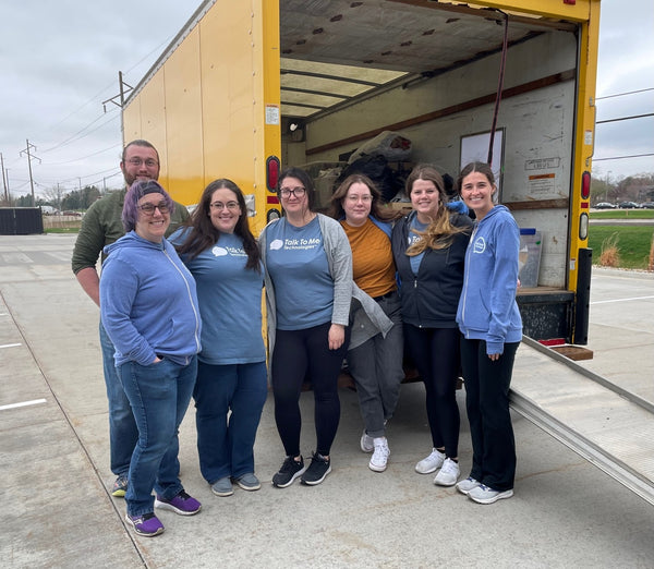 Part of the funding team standing in front of an unloaded truck smiling